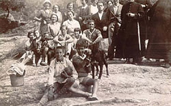 Celebració a Farners de l'acabament de les vacances, a finals de setembre de l'any 1930 o 1931. Vinyoli està dret al costat del capellà que porta paraigües (la fotografia està escapçada just pel seu front). La segona senyora que està dreta al darrera és Emília Pladevall, mare del poeta, i la nena que està al centre de la foto la seva germana Carme.  (Arxiu Anna R. Monegal)